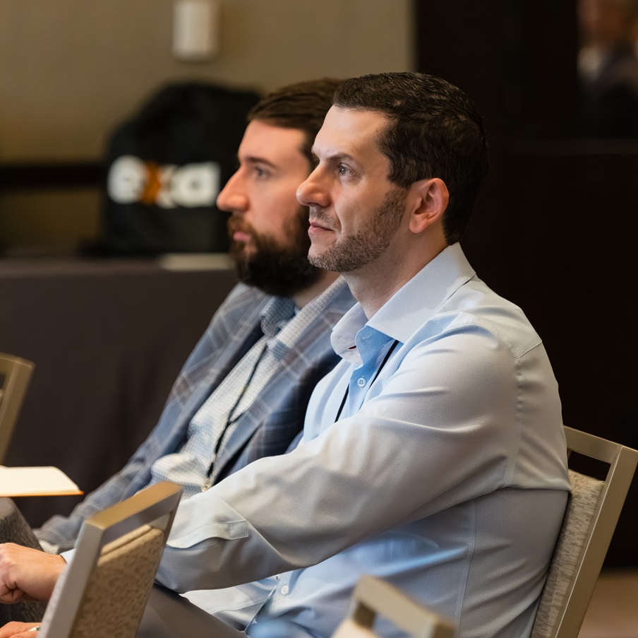 Valicom leaders listening at an industry event
